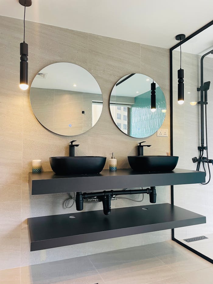 Elegant bathroom interior featuring double sinks and round mirrors.